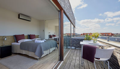 Soveværelse med altan i penthouse hotellejlighed i København