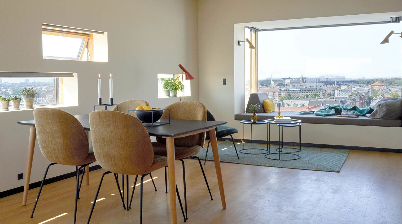 Spisebord og sofa i vindue med udsigt over København i 50 m2 hotellejlighed