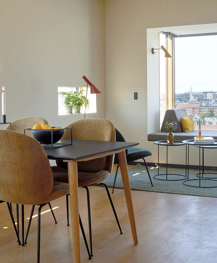 Spisebord og sofa i vindue med udsigt over København i 50 m2 hotellejlighed